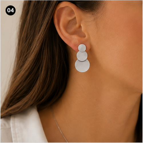 Boucle d’oreille argentée à trois disques NIRMEN portée à l’oreille